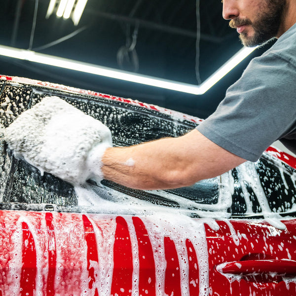 Red car being washed with sudsy mitt; Turtle Wax shine for a clean auto, India.