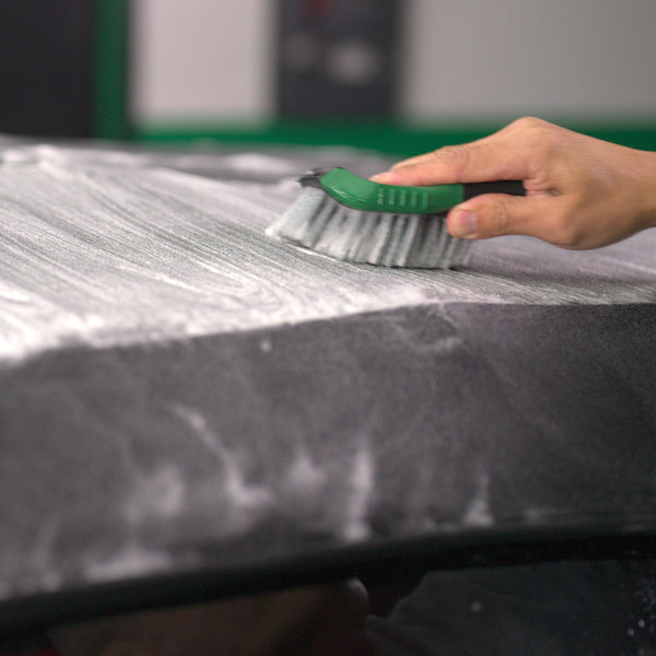 Cleaning fabric with a brush and Turtle Wax Hybrid Solutions cleaner in India.