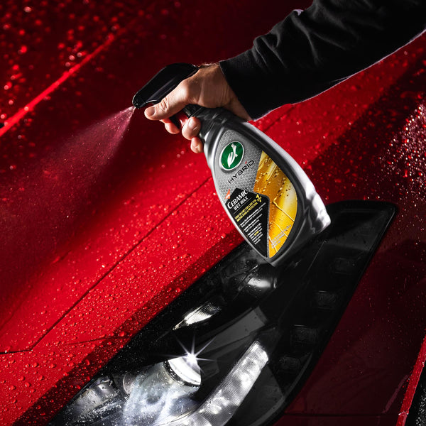 Turtle Wax Hybrid Ceramic Wet Wax being sprayed onto a red car. Car care product for shine and protection.