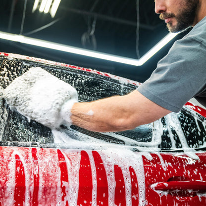 Red car being washed with sudsy mitt; Turtle Wax shine for a clean auto, India.
