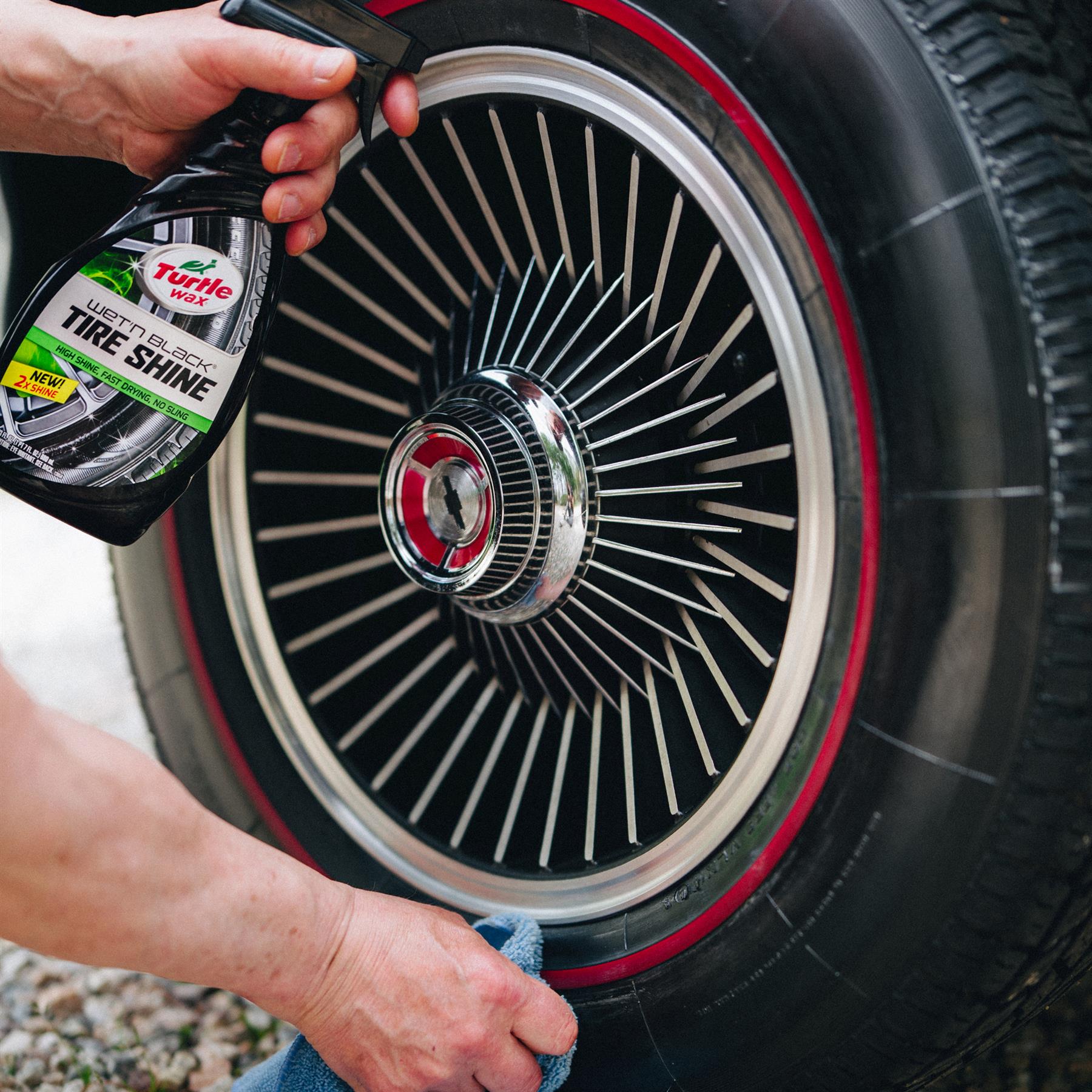 Turtle Wax Wet'n Black Tire Shine being applied to a car tire with a red-lined wheel. Car detailing & maintenance in India.
