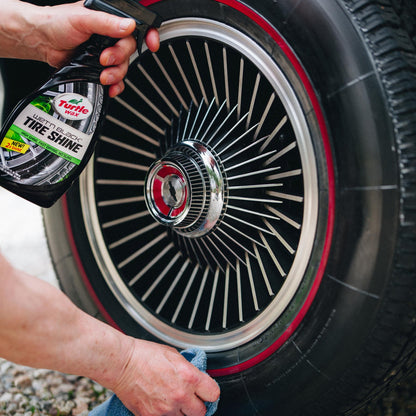 Turtle Wax Wet'n Black Tire Shine being applied to a car tire with a red-lined wheel. Car detailing & maintenance in India.