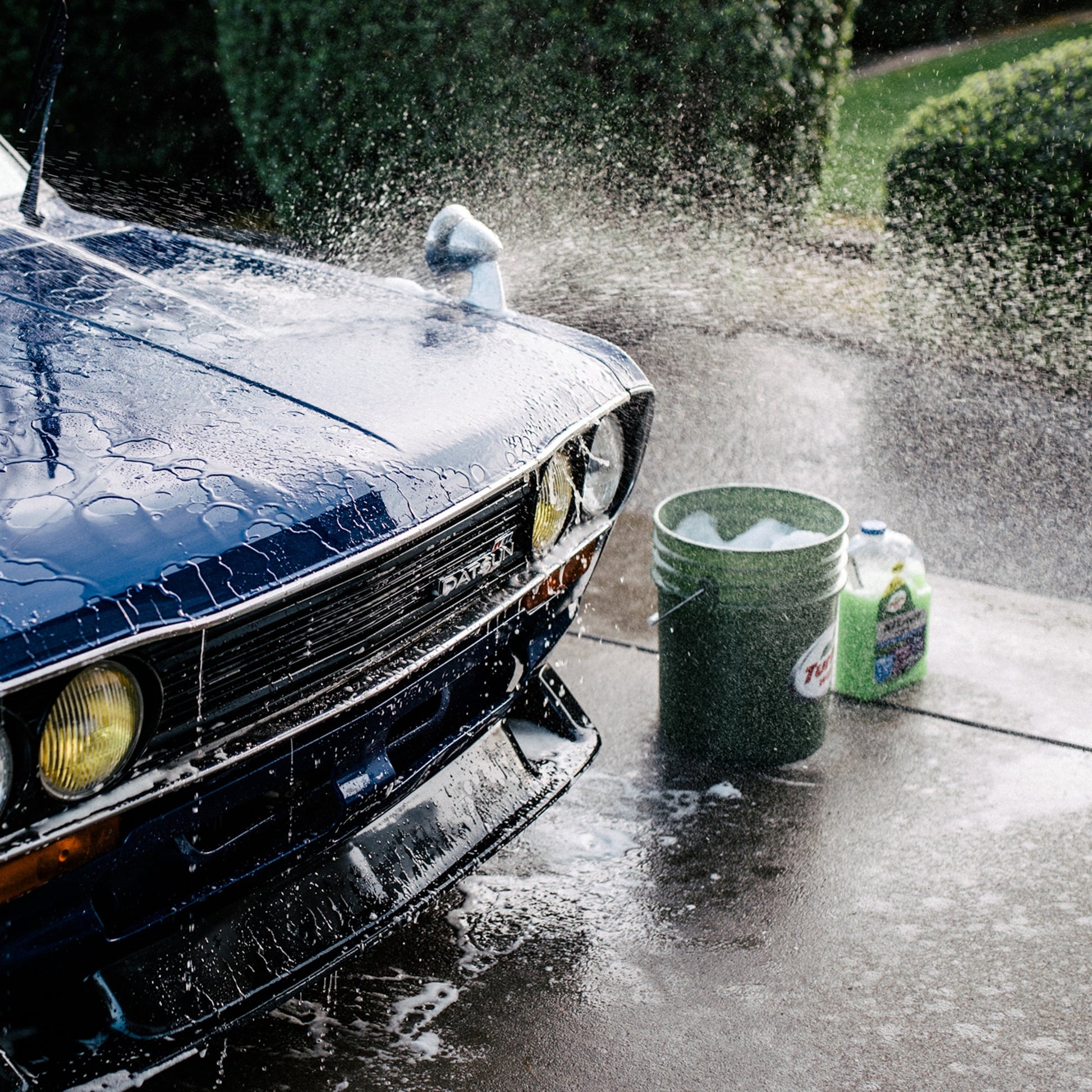 Blue Datsun car being washed. Turtle Wax car wash liquid visible. Car detailing India.