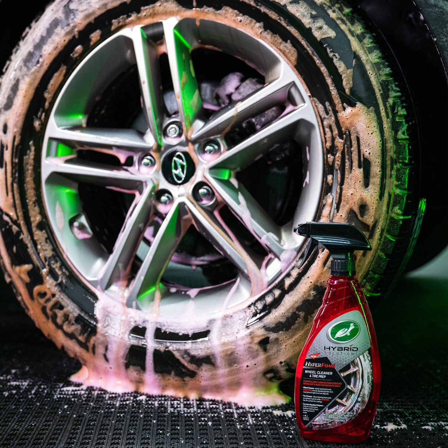 Turtle Wax: Car wheel & tyre with clinging foam after cleaning. Wheel cleaner bottle shown. Ideal for Indian car care.
