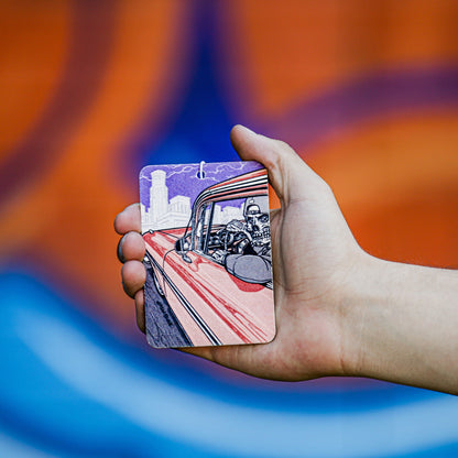 हाथ में पेपर एयर फ्रेशनर है, जिसमें कार में एक खोपड़ी का चित्रण है।