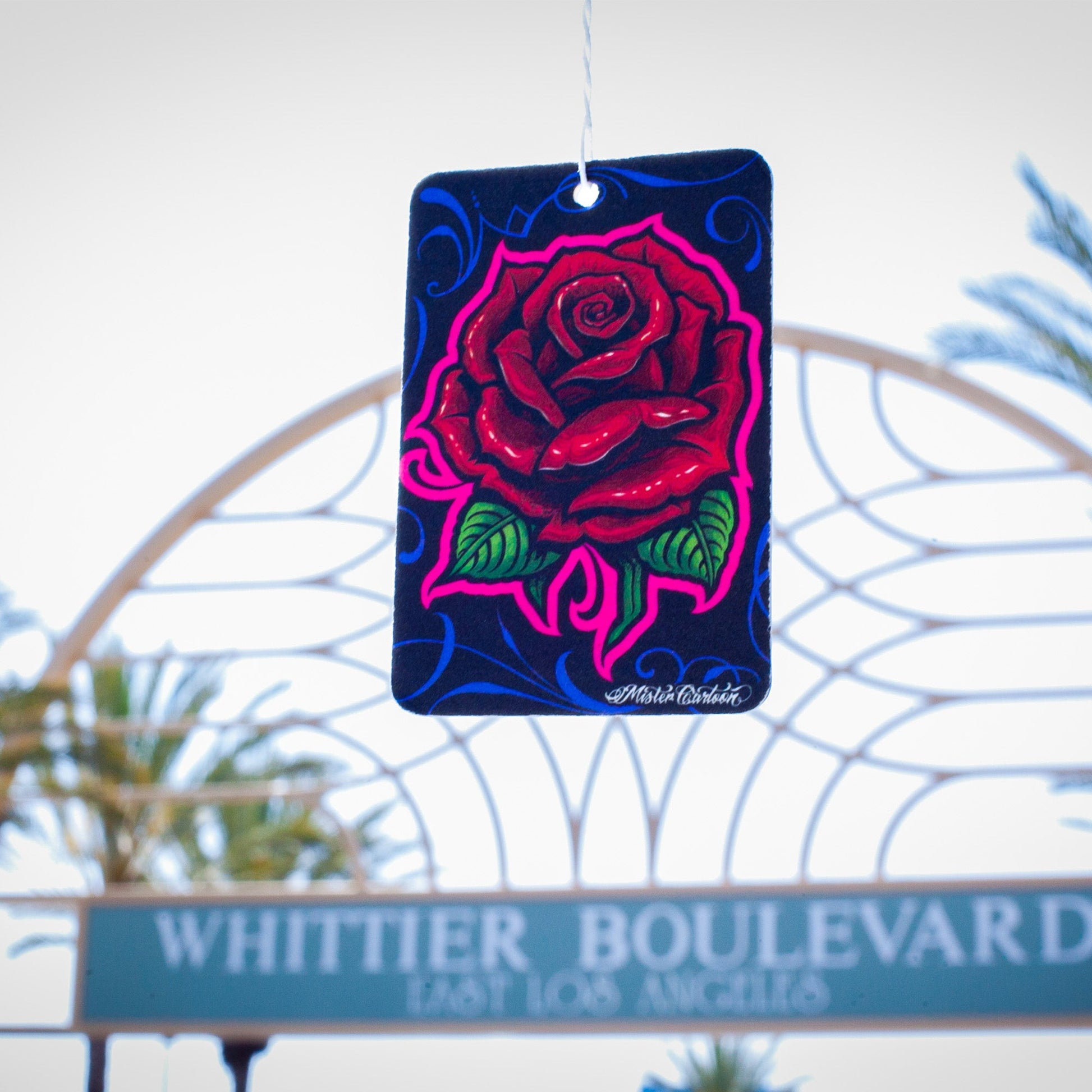 Automotive paper freshener with rose design, hanging on Whittier Boulevard, Los Angeles. Car accessories India.
