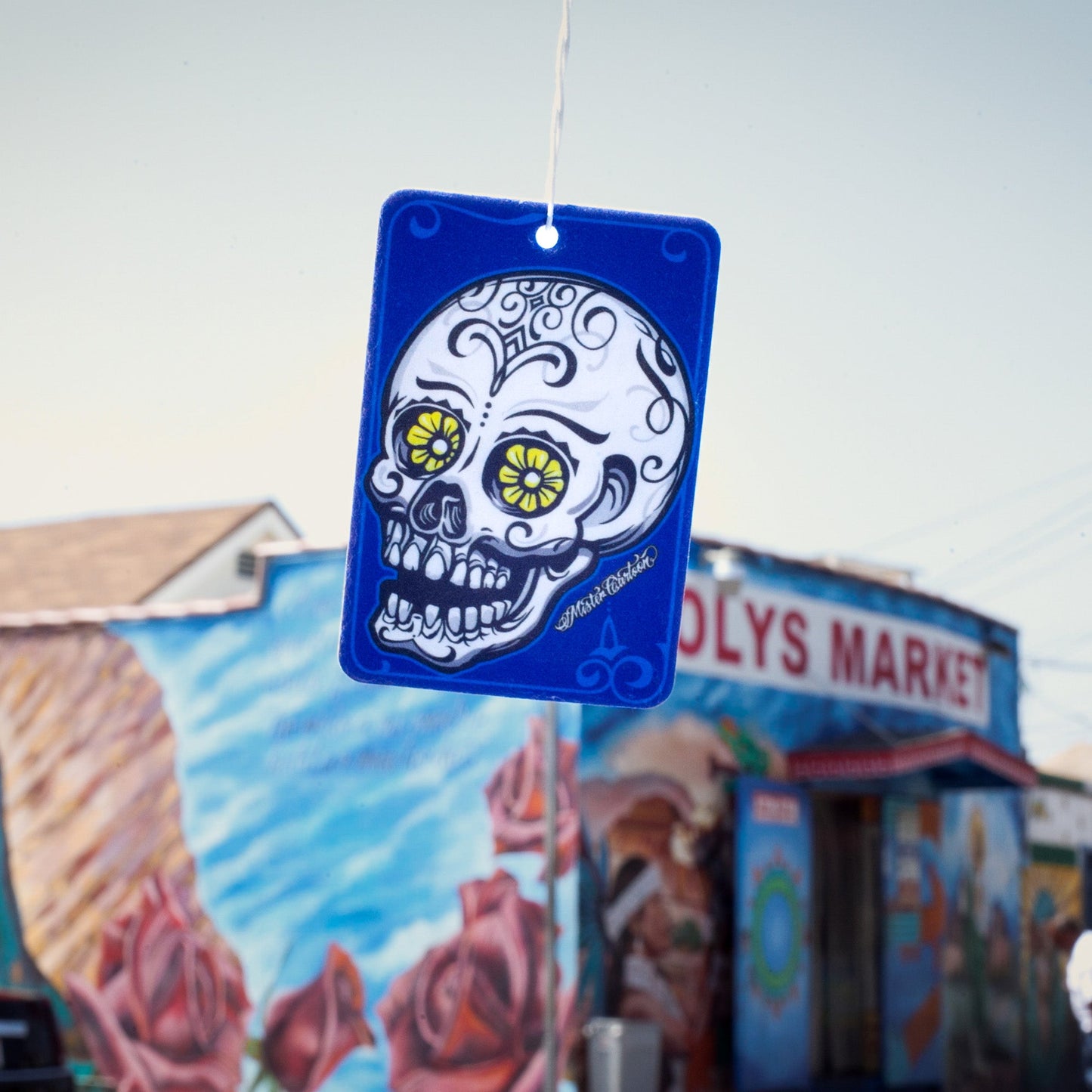 Blue air freshener with a skull art. Indian auto accessories and car fragrance item.