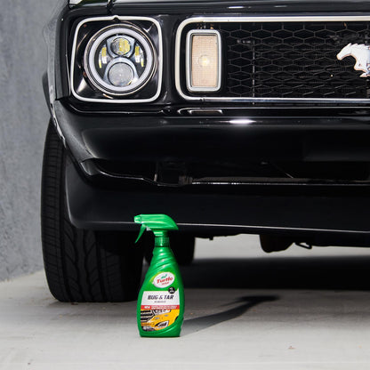 Turtle Wax Bug & Tar Remover near classic black car's headlight and grill. Mustang pony logo visible. Car care in India.