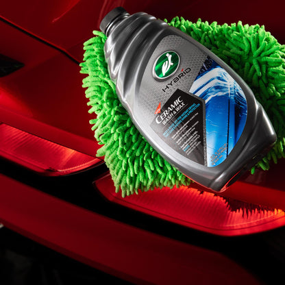 Turtle Wax Hybrid Solutions Ceramic Wash & Wax bottle on a red car with a green microfiber towel. Ideal for car detailing in India.