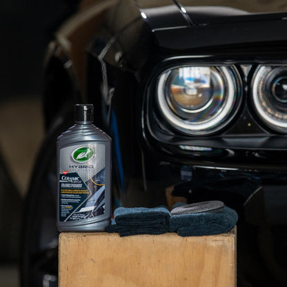 Turtle Wax Hybrid Solutions ceramic acrylic black polish 414ml for car care, next to a black car. Auto detailing supplies for Indian vehicles.