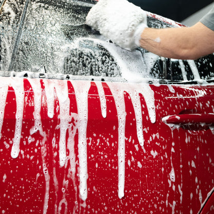 Red car getting washed with Turtle Wax foam. Auto detailing for a sparkling finish.