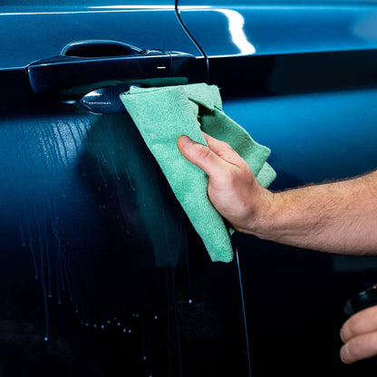 Car detailer buffing a blue car door. Turtle Wax product used.