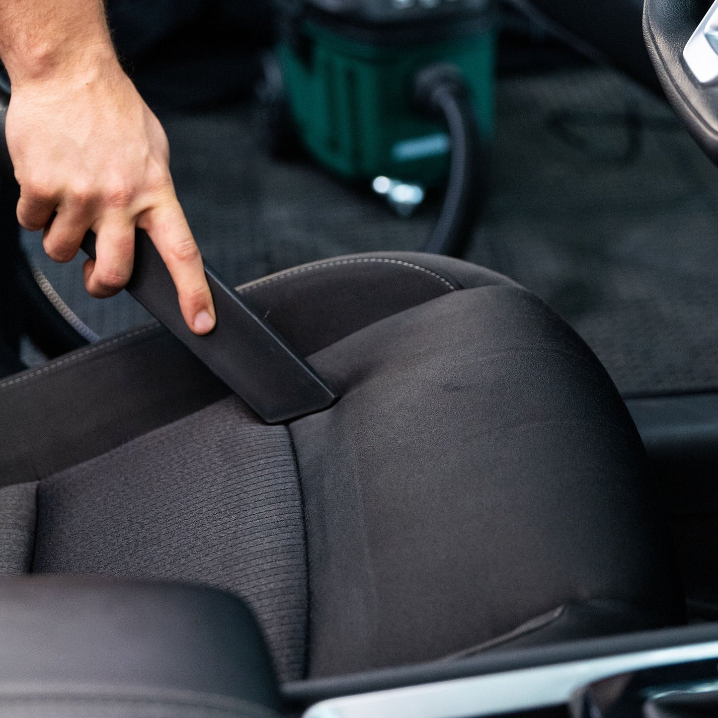 Detailing a car seat interior using a machine. Car care maintenance for cleaning automotive cloth.