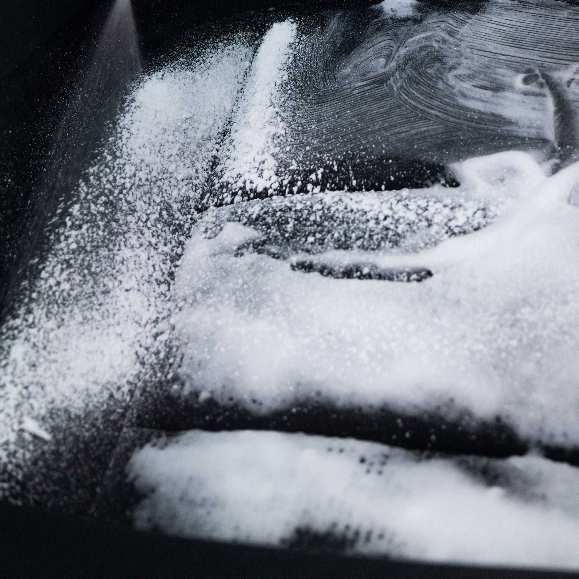 Foam cleaner on black surface. Marks left behind. Cleaning spray.