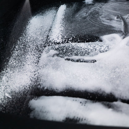 Foam cleaner on black surface. Marks left behind. Cleaning spray.