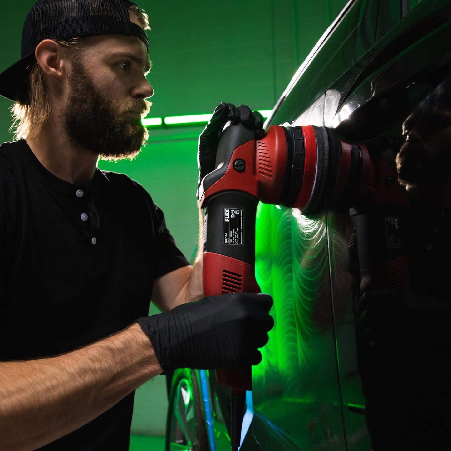 Auto detailer using a machine buffer on a car panel. Swirl marks visible. Car care in India.
