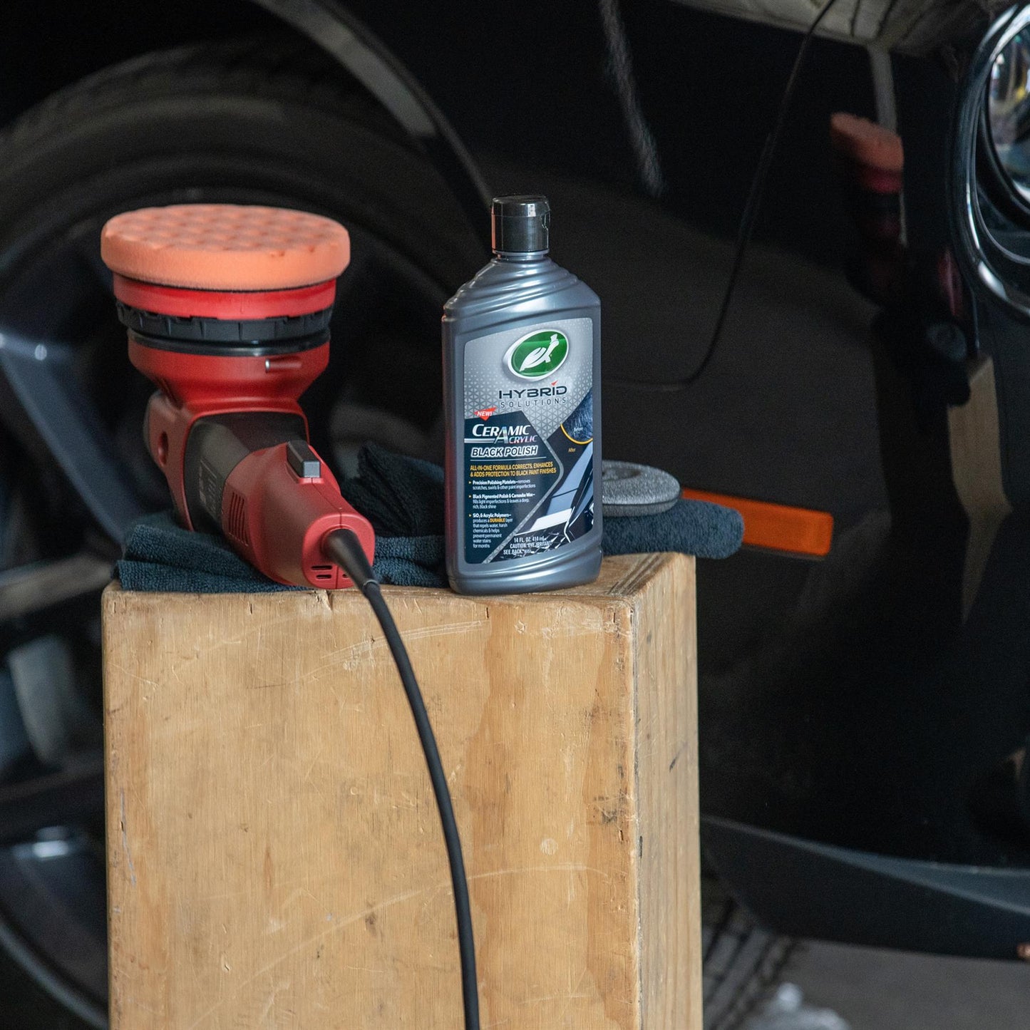 Black car detailing: Turtle Wax Hybrid Solutions Ceramic Acrylic Black Polish and power buffer shown, for scratch removal.
